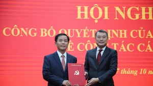 El miembro del Buró Político, secretario del Comité Central del PCV y jefe de su Comisión de Organización, Le Minh Hung (derecha), entrega la decisión a Nguyen Van Phuong. (Foto: GP)
