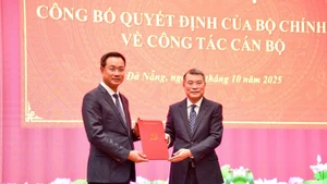 Le Minh Hung, (derecha) miembro del Buró Político, secretario del Comité Central del PCV y jefe de su Comisión de Organización, presenta la decisión del nombramiento a Le Ngoc Quang. (Foto: VGP)