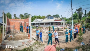 Vietnamitas uniéndose para eliminar casas temporales y deterioradas. (Foto: VNA)