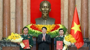 El presidente vietnamita, Luong Cuong, entrega las decisiones a Do Xuan Tung y Do Van Banh. (Foto: Nhan Dan)