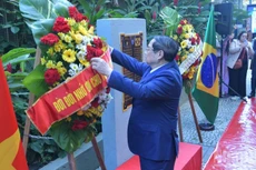 El primer ministro Pham Minh Chinh coloca flores en la placa en conmemoración del Presidente Ho Chi Minh en la ciudad de Río de Janeiro, Brasil, el 5 de julio. (Foto: Nhan Dan)