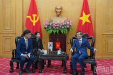El director de la Academia Nacional de Política Ho Chi Minh, Doan Minh Huan (derecha), recibe al director general del Grupo Samsung Vietnam, Na Ki Hong. 