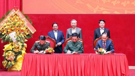 El secretario general del Partido Comunista, To Lam, el presidente, Luong Cuong, y el primer ministro, Pham Minh Chinh, presencian la firma de las nuevas normas de coordinación entre los Ministerios de Seguridad Pública, de Defensa y de Relaciones Exteriores el 6 de diciembre. (Foto: VNA)