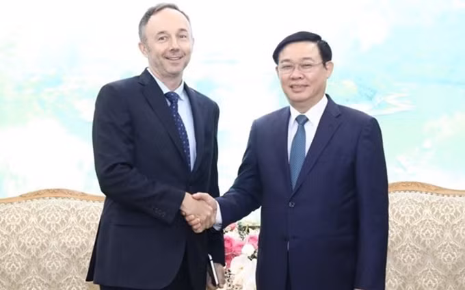 El viceprimer ministro Vuong Dinh Hue recibe al vicepresidente de Nike, Chris Helzer (Fotografía: VNA)