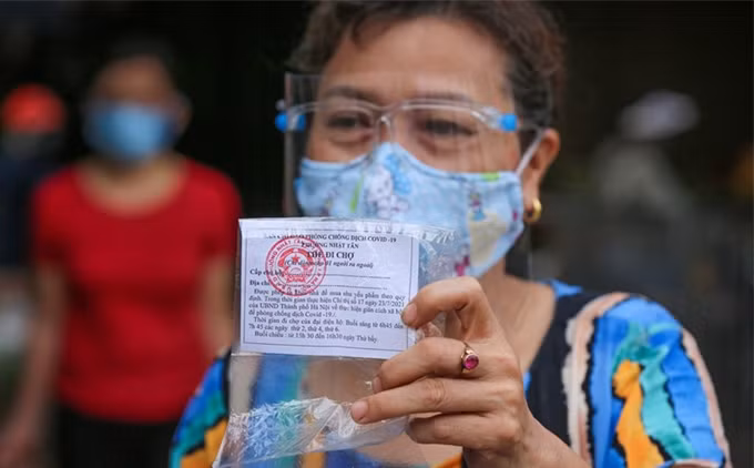 Cada familia recibe cinco tarjetas para 15 días, en las cuales se escribe el nombre de quien sale y la dirección de su casa. (Fotografía: VNA)
