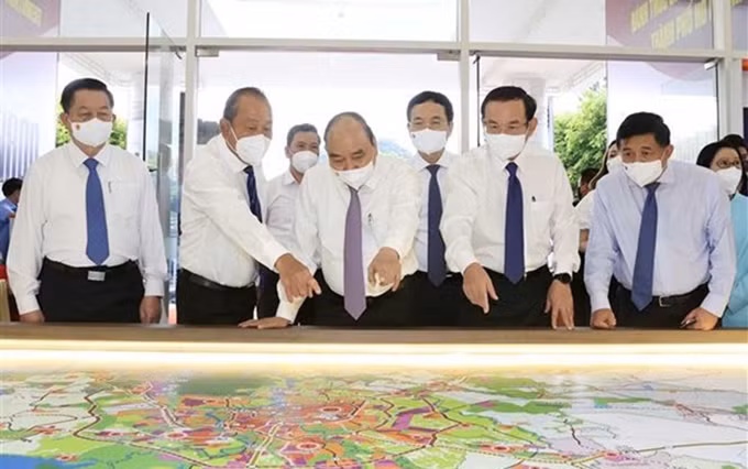 El presidente de Vietnam, Nguyen Xuan Phuc, revisa el mapa de planificación de los distritos de Hoc Mon y Cu Chi (Foto: VNA)
