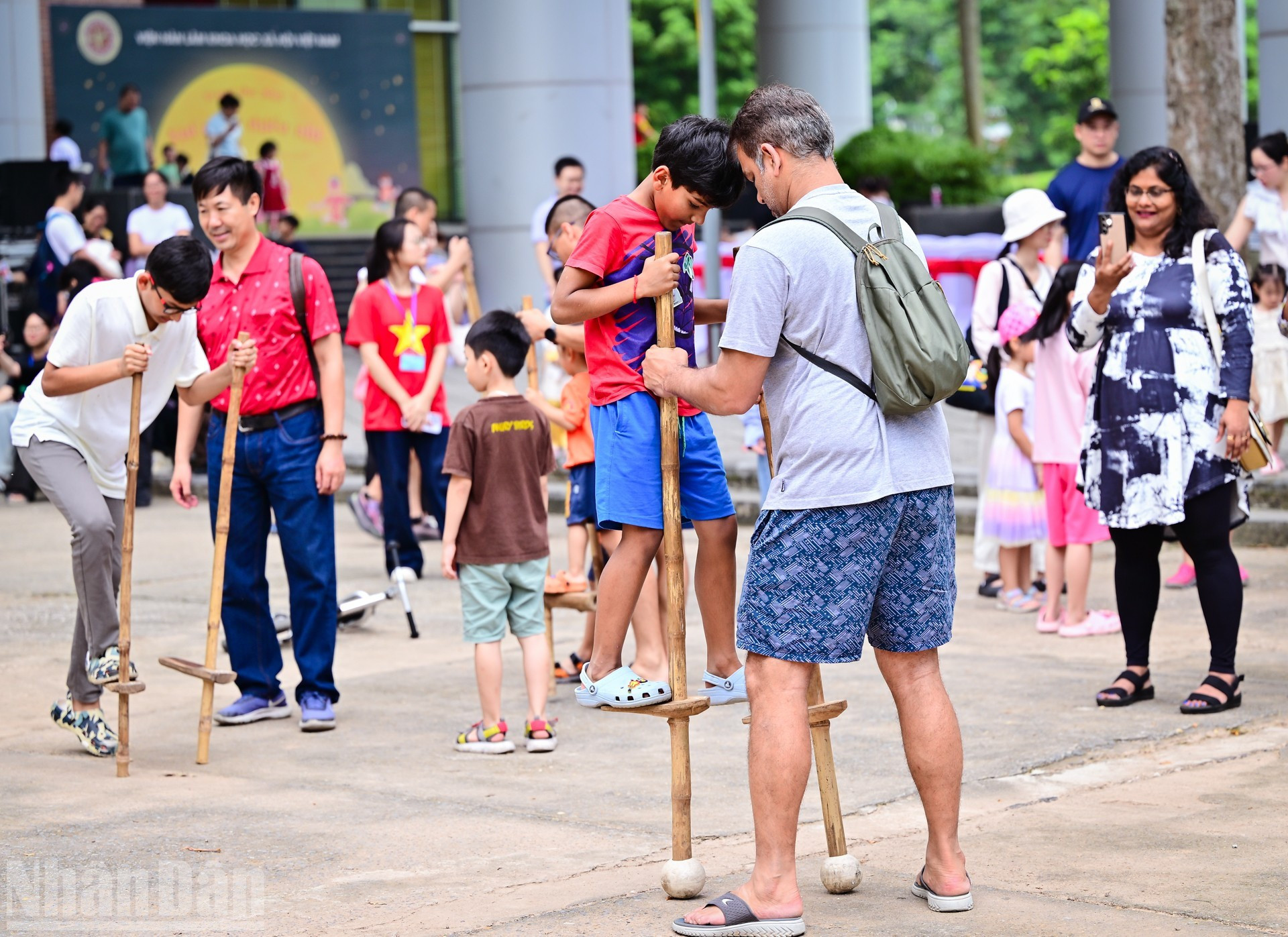 El programa también impresiona a los turistas extranjeros, quienes disfrutaron mucho jugando al juego tradicional de caminar sobre zancos.