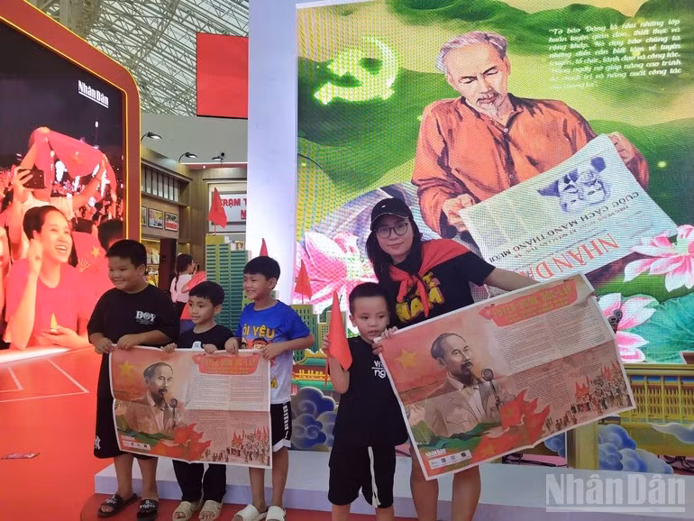 Los niños, que acuden con sus familias a visitar la exposición, posan muy orgullosos para hacerse fotos con el suplemento que lleva la imagen del Presidente Ho Chi Minh leyendo la Declaración de Independencia el 2 de septiembre de 1945.