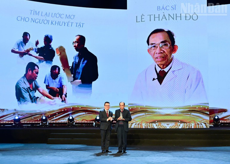 El presidente-editor del periódico Nhan Dan, Le Quoc Minh, entrega el premio al doctor Le Thanh Do, quien durante más de 20 años ha fabricado y entregado de manera gratuita miles de prótesis de brazos y piernas a personas con discapacidad de escasos recursos en todo el país.