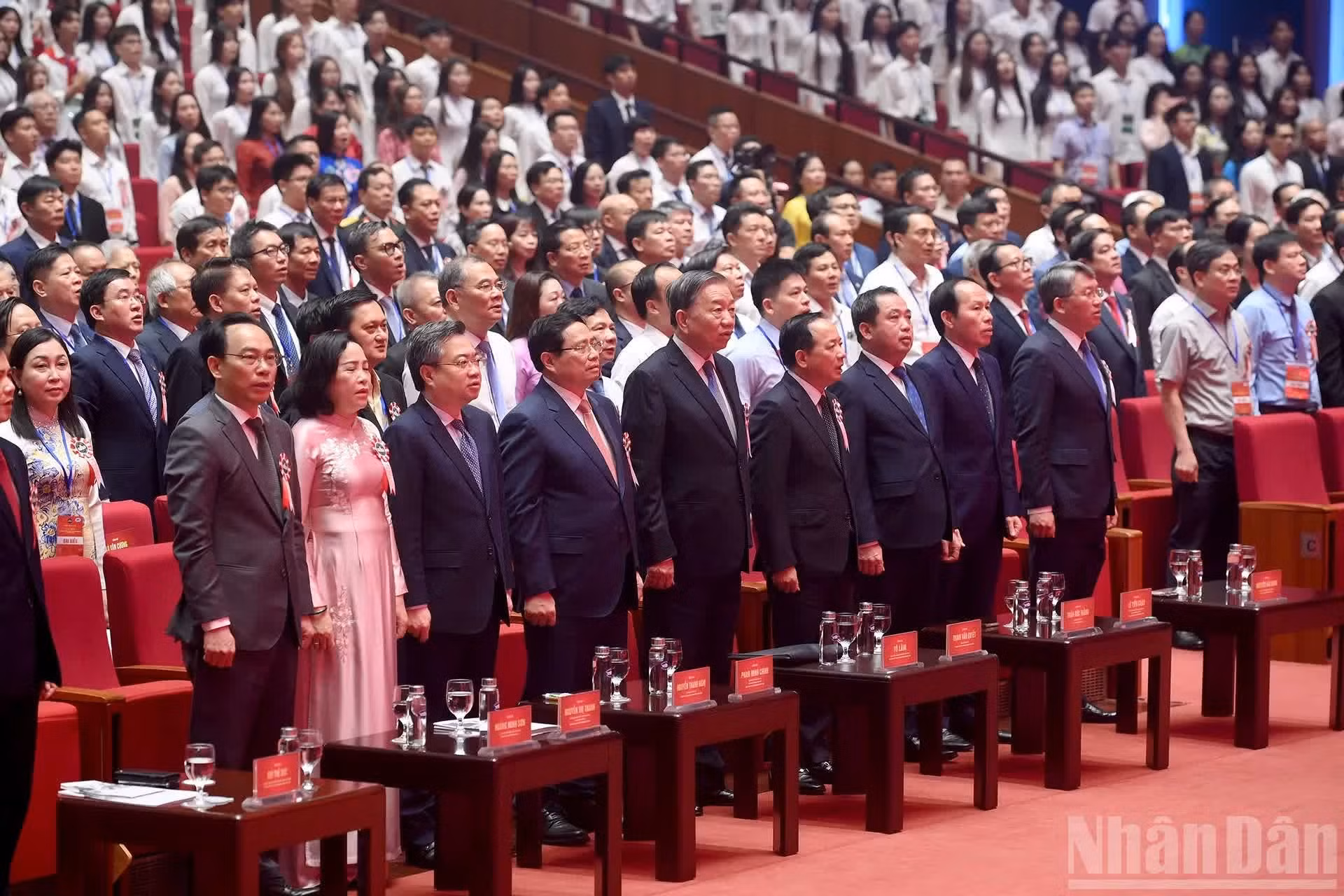Los asistentes realizan el acto de saludo a la bandera.