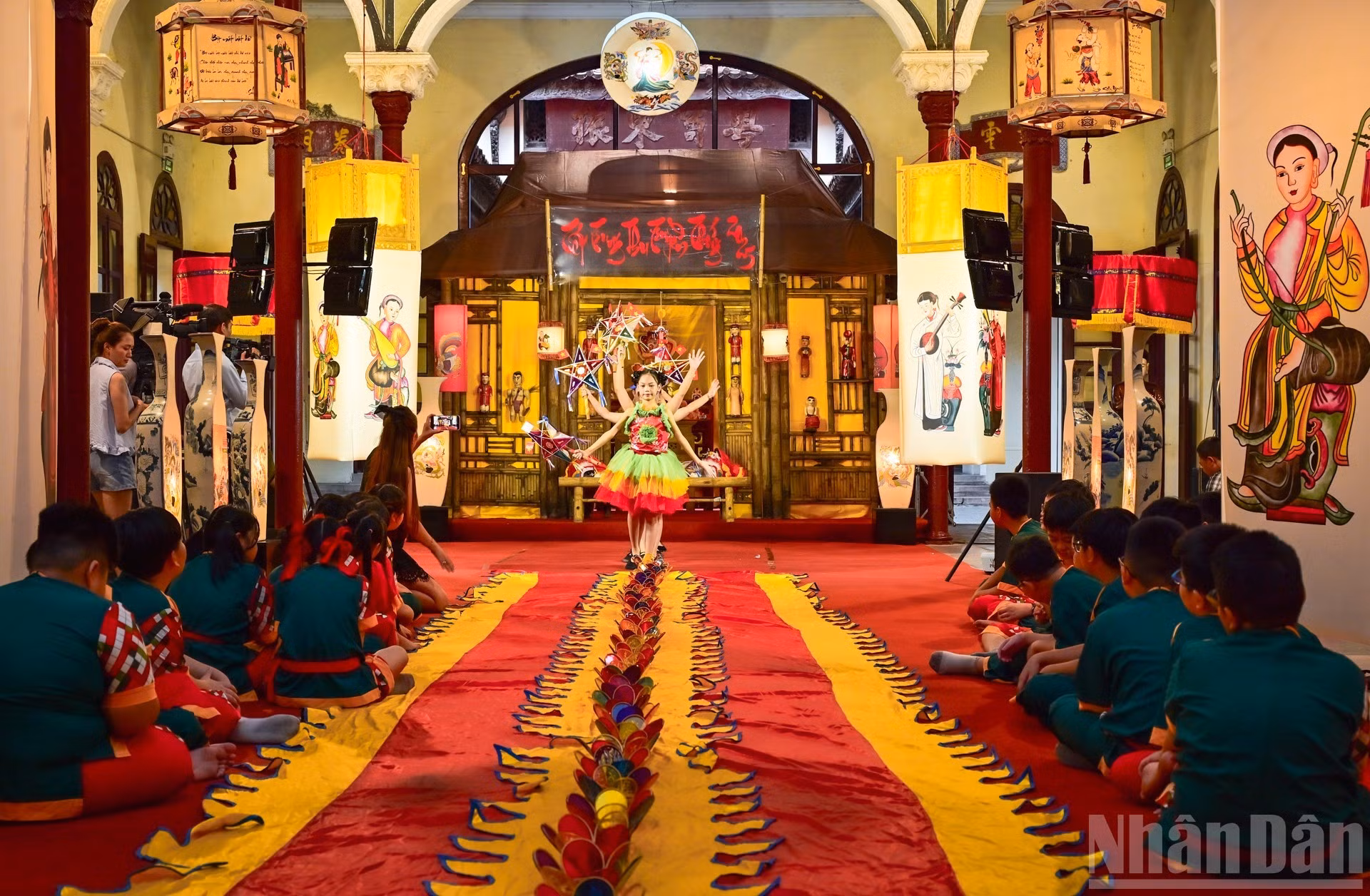 Una actuación artística acompañada de linternas de estrella, típicas del Festival del Medio Otoño, resalta los colores y el ambiente festivo característico.