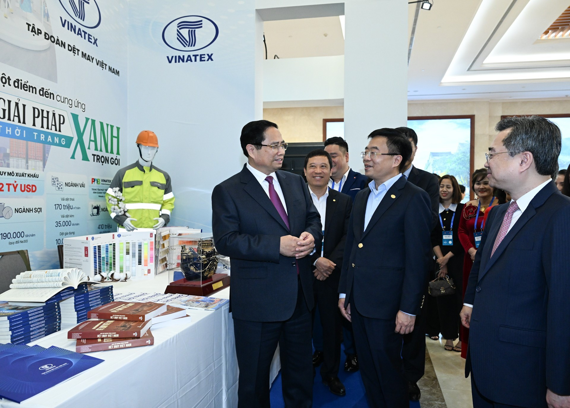 El primer ministro Pham Minh Chinh visita los stands de exhibición de productos en el evento.