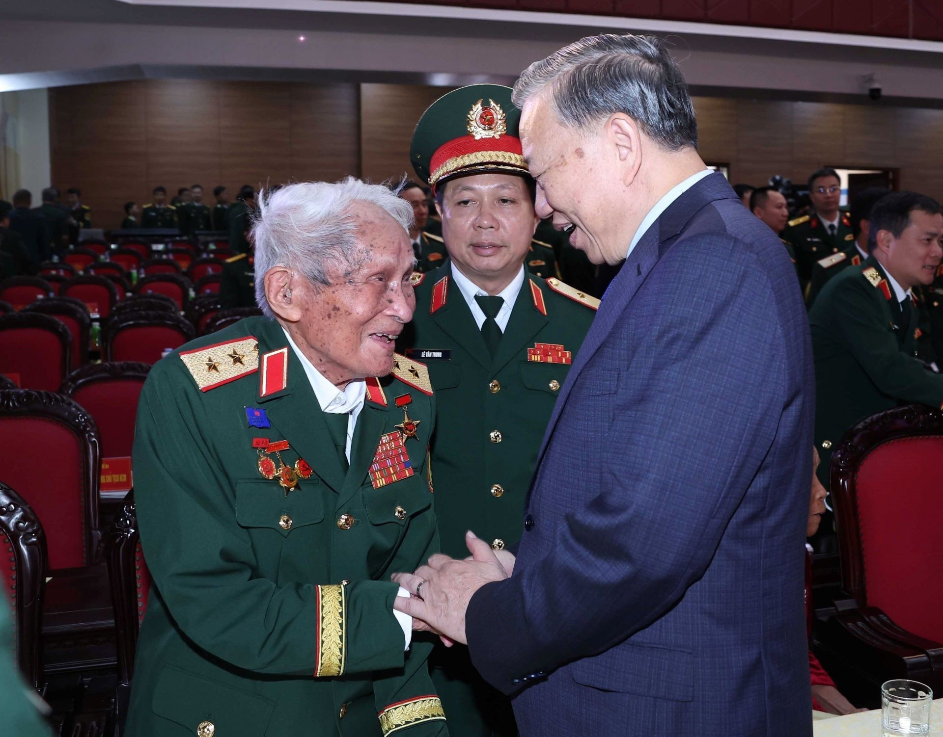 El secretario general del PCV, To Lam, saluda al teniente general Nguyen Quoc Thuoc, excomandante de la Zona Militar 4.