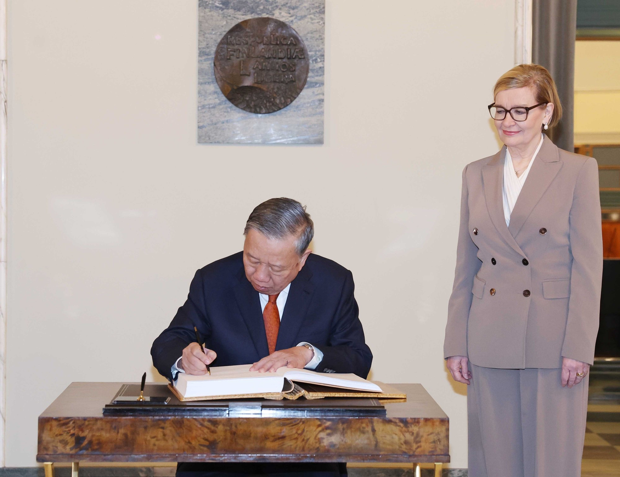El secretario general del Partido Comunista de Vietnam, To Lam, firma libro de recuerdo.