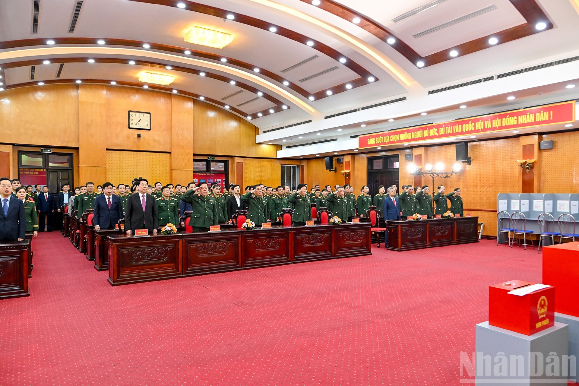 Los asistentes realizan el acto de saludo a la bandera nacional.