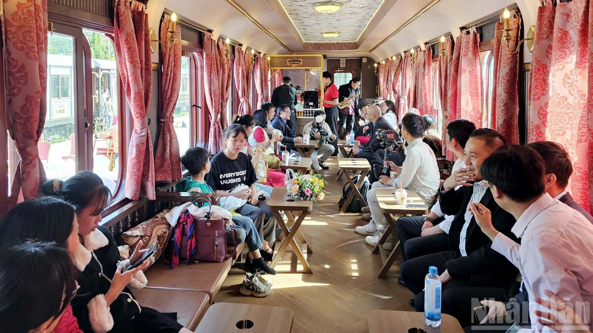 Los turistas disfrutan del café vietnamita y de la música en los vagones antiguos del Tren del Café de Da Lat.