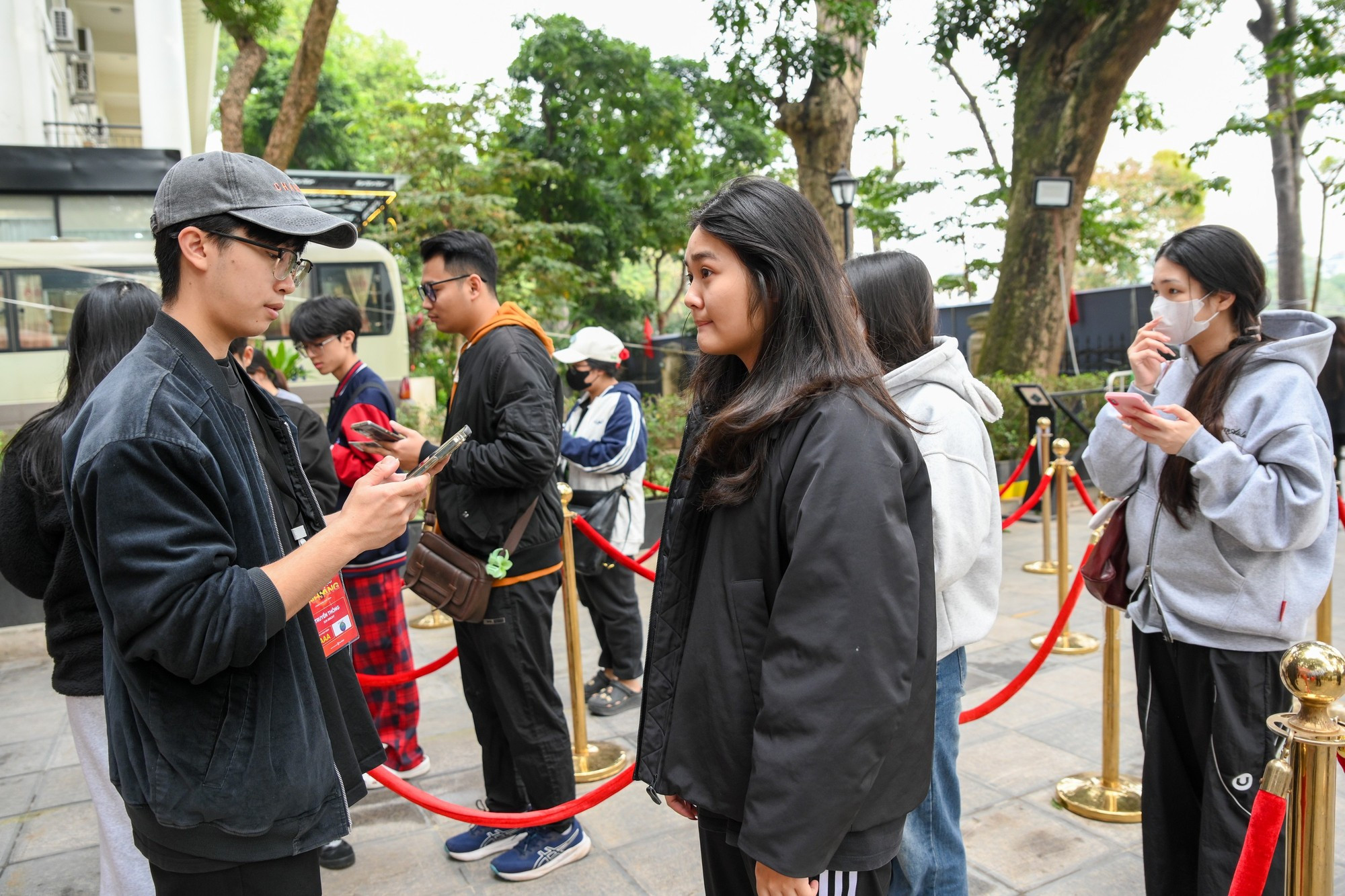 Los jóvenes hacen cola para escanear códigos QR, lo que les da acceso a las entradas para el evento.