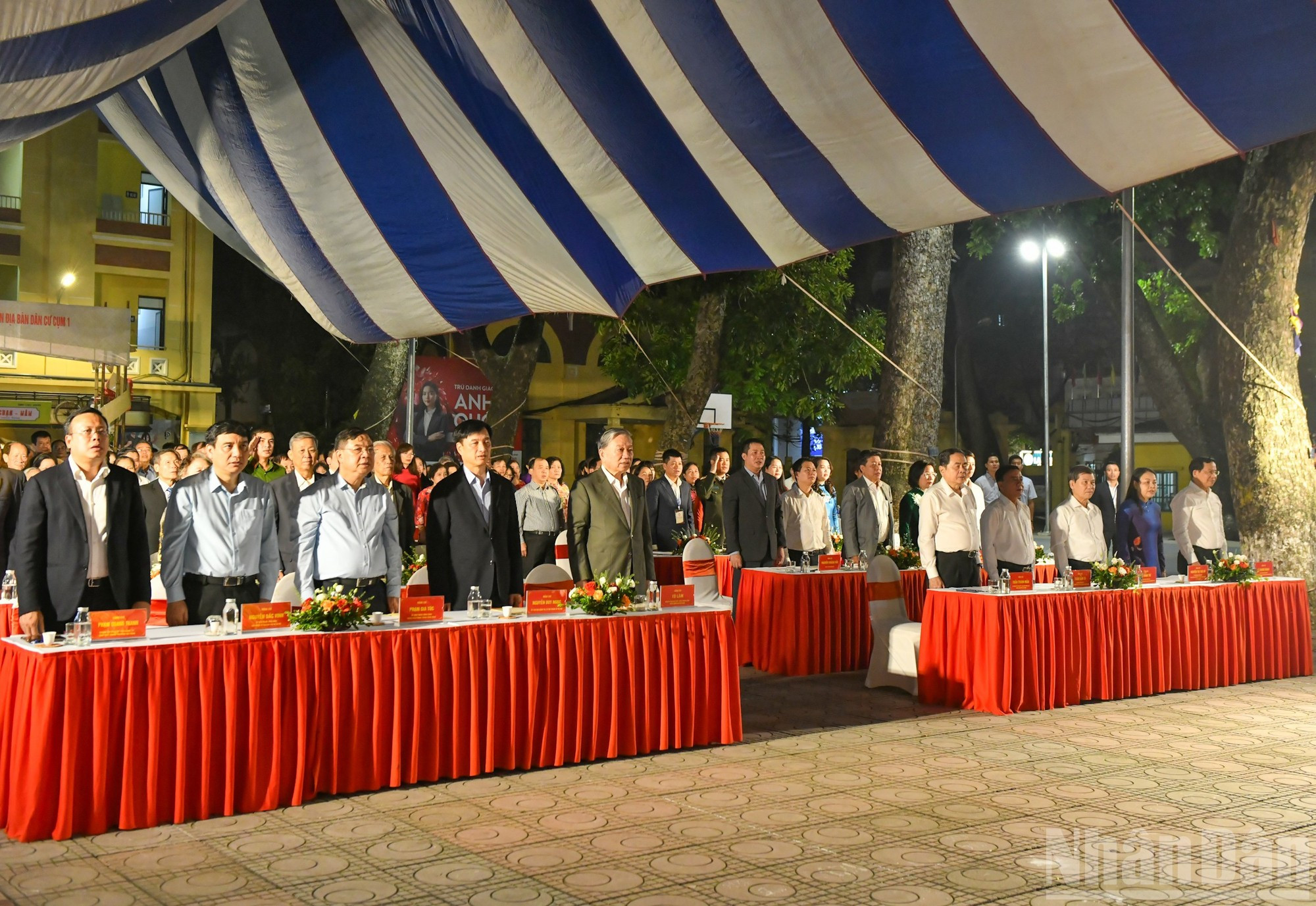 Los asistentes realizan la ceremonia de saludo a la bandera nacional.