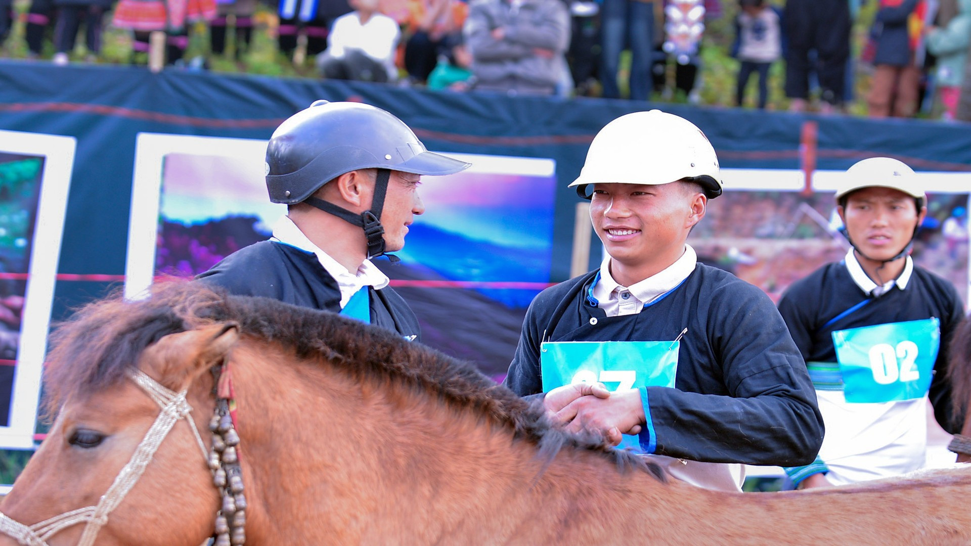 Los jinetes sostienen sus manos antes de la competencia.
