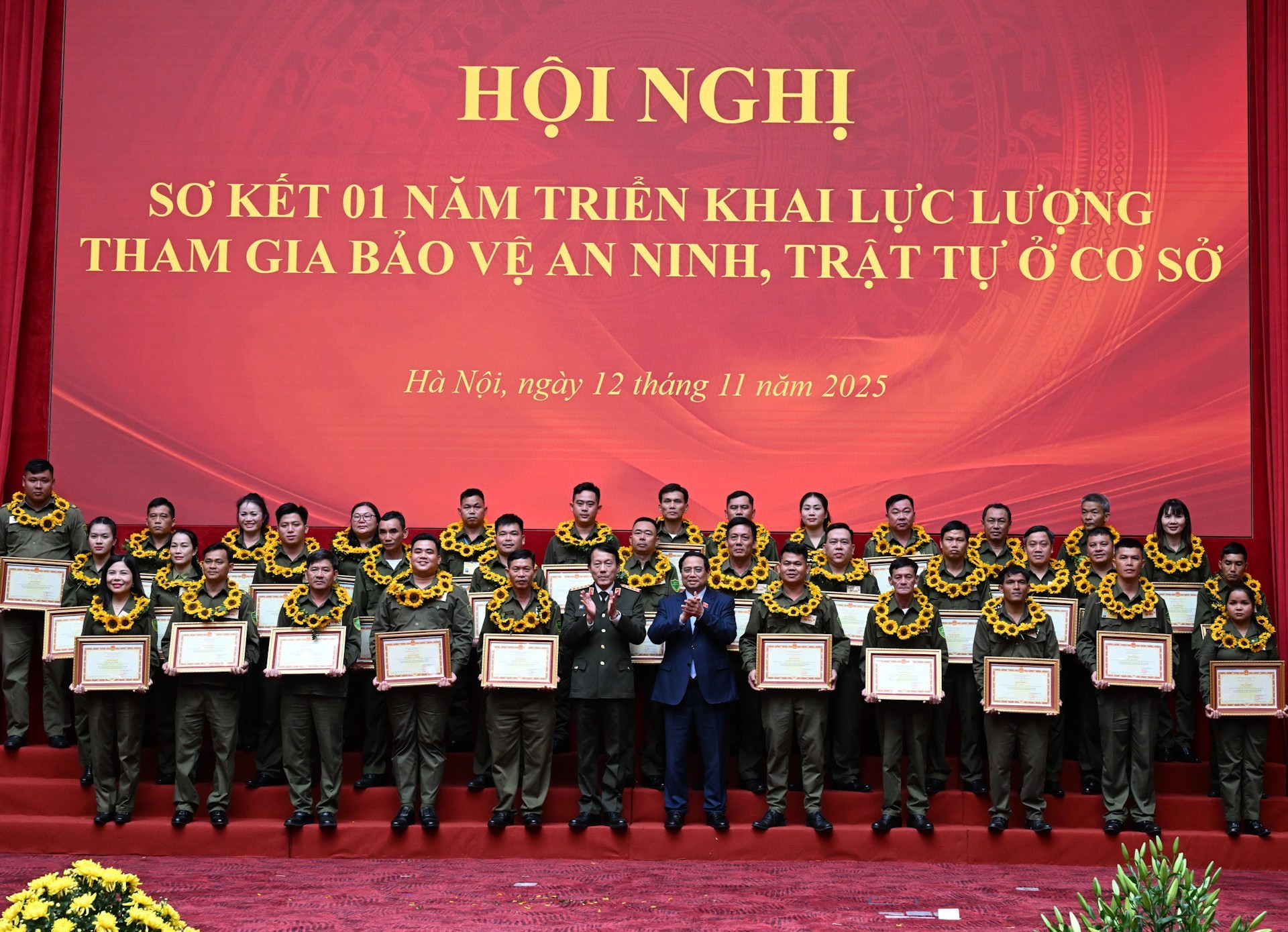 El premier Pham Minh Chinh y el ministro de Seguridad Pública, Luong Tam Quang, entrega certificados de mérito a colectivos e individuos destacados.