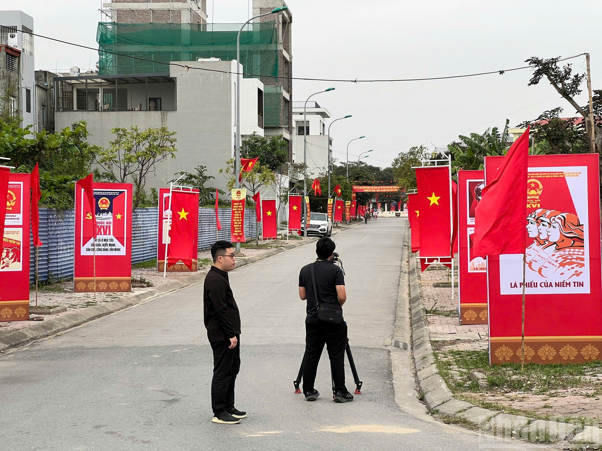 Los reporteros documentan el ambiente del día electoral en los centros de votación, decorados de manera colorida con banderas, paneles y carteles de propaganda.