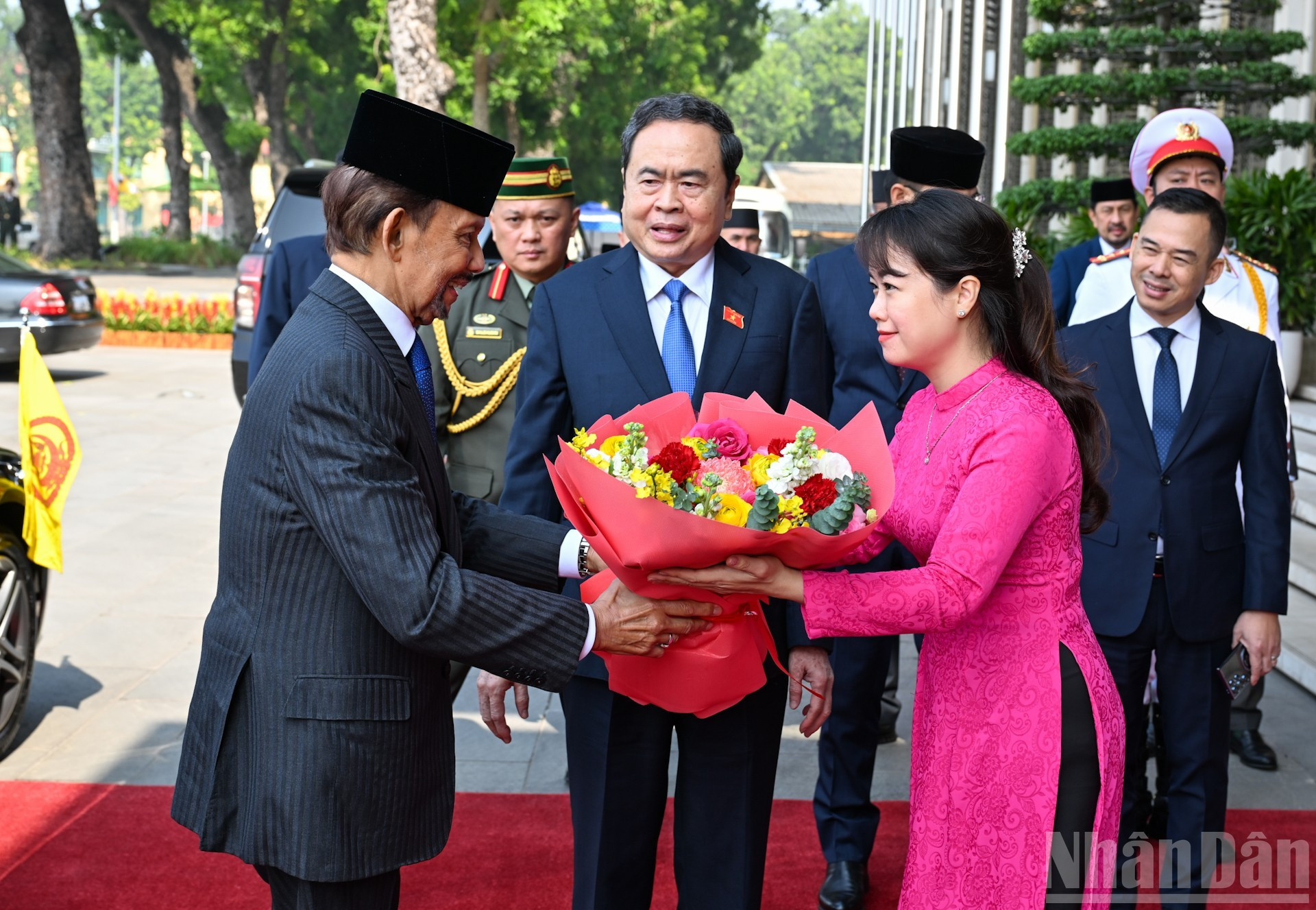 Una personal de la Oficina de la ANV entrega flores de bienvenida al sultán de Brunéi Darussalam, Haji Hassanal Bolkiah.