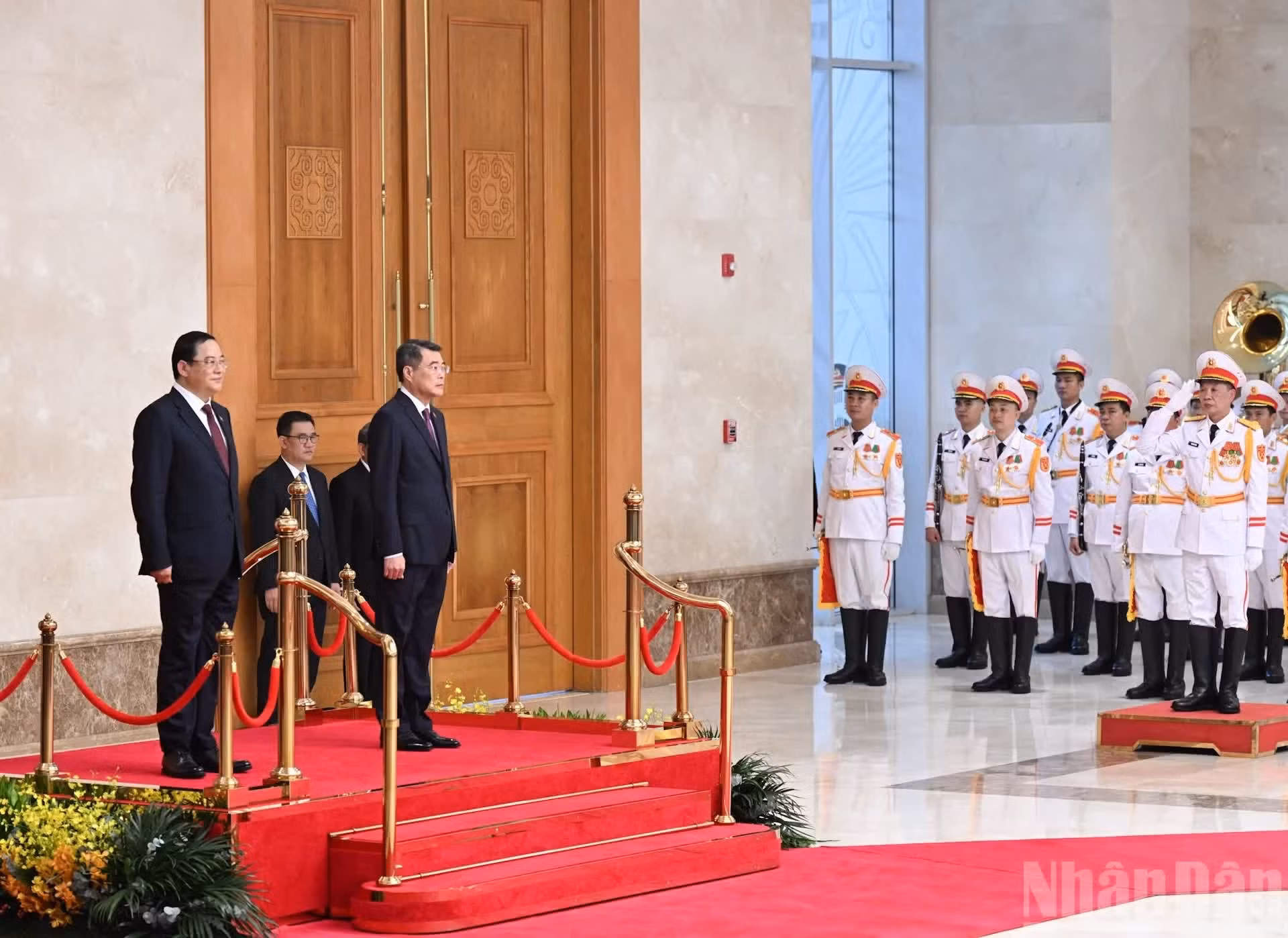 El premier Le Minh Hung, y su par laosiano, Sonexay Siphandone, realizan el acto de saludo a las banderas nacionales de Vietnam y de Laos.