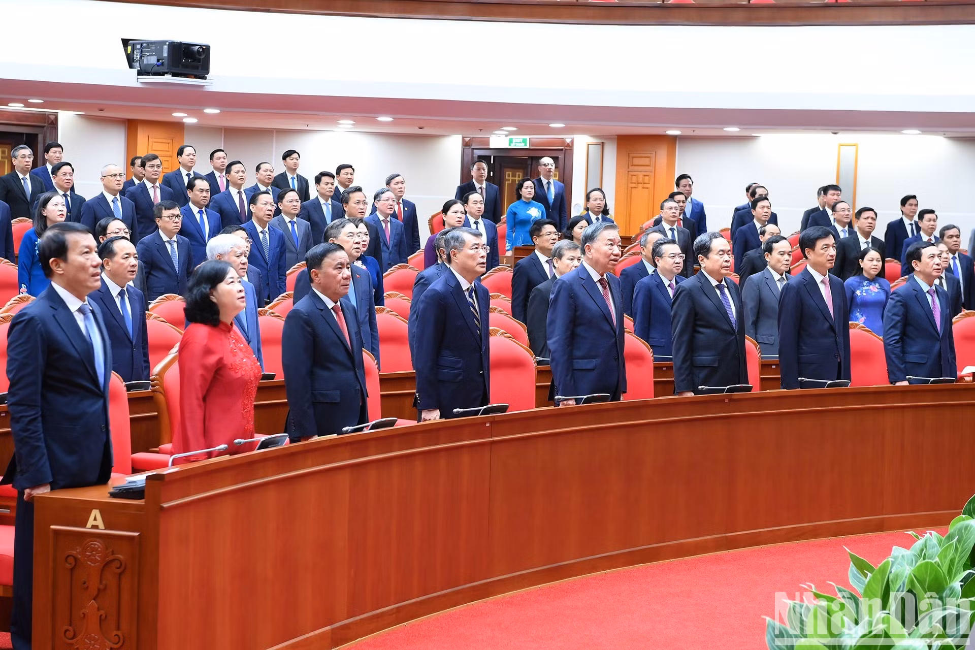Los asistentes realizan el acto del saludo a la bandera nacional.