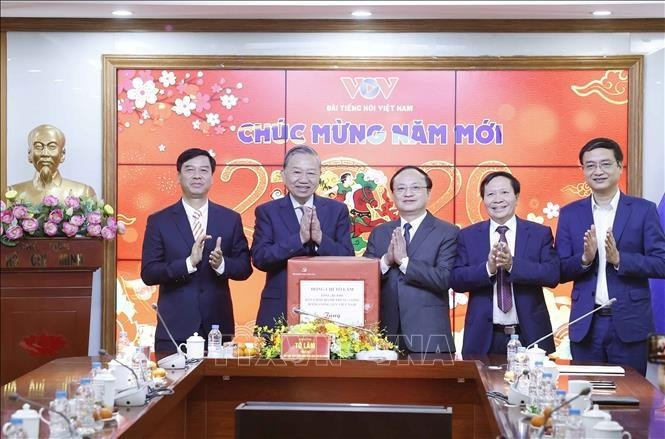 El secretario general To Lam (segunda a la izquierda), entrega regalos a trabajadores, periodistas y técnicos de la Voz de Vietnam.