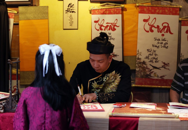 Turistas visitan y aprenden sobre las costumbres tradicionales del Tet del pueblo vietnamita.