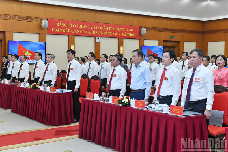 Los asistentes saludan la bandera nacional.