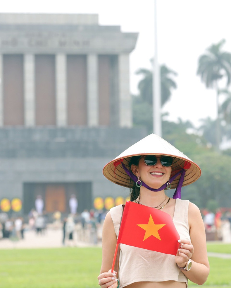Los visitantes extranjeros disfrutan tomándose fotos con la bandera vietnamita. Los visitantes extranjeros disfrutan tomándose fotos con la bandera vietnamita.