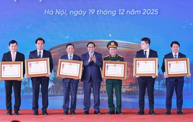 El primer ministro Pham Minh Chinh entrega la Orden de Trabajo de Tercera Clase a los colectivos e individuos con resultados sobresalientes en la implementación de importantes proyectos nacionales (Foto: VNA)