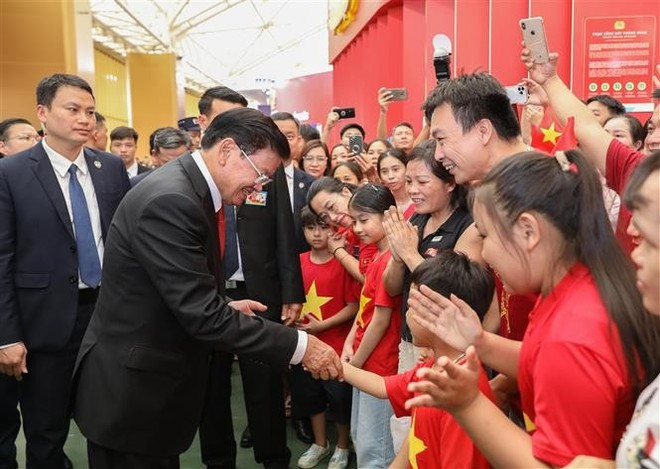 El secretario general del Partido Popular Revolucionario y presidente de Laos, Thongloun Sisoulith, interactúa con niños en el Centro Nacional de Exposiciones en Hanói. (Foto: VNA) El secretario general del Partido Popular Revolucionario y presidente de Laos, Thongloun Sisoulith, interactúa con niños en el Centro Nacional de Exposiciones en Hanói. (Foto: VNA)