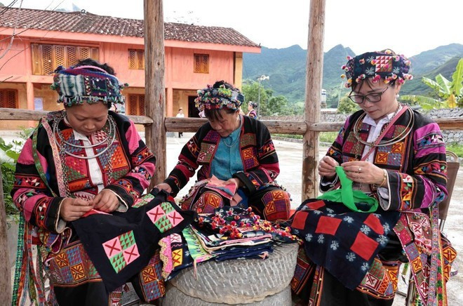 Las mujeres de la minoría étnica Lo Lo bordan hábilmente diseños en trajes tradicionales. (Foto. VNA)
