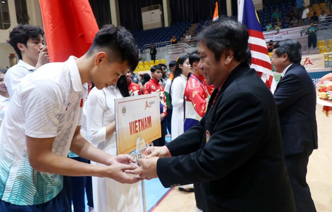 Teddy Suratmadji, secretario general de la Federación Mundial de Pencak Silat, entrega copa conmemorativa a la delegación vietnamita. (Foto: VNA) Teddy Suratmadji, secretario general de la Federación Mundial de Pencak Silat, entrega copa conmemorativa a la delegación vietnamita. (Foto: VNA)