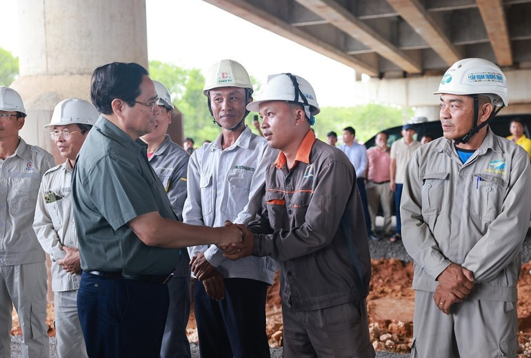Minh Chinh con obreros del proyecto del tramo Van Ninh-Cam Lo de la autopista Norte-Sur. Minh Chinh con obreros del proyecto del tramo Van Ninh-Cam Lo de la autopista Norte-Sur.