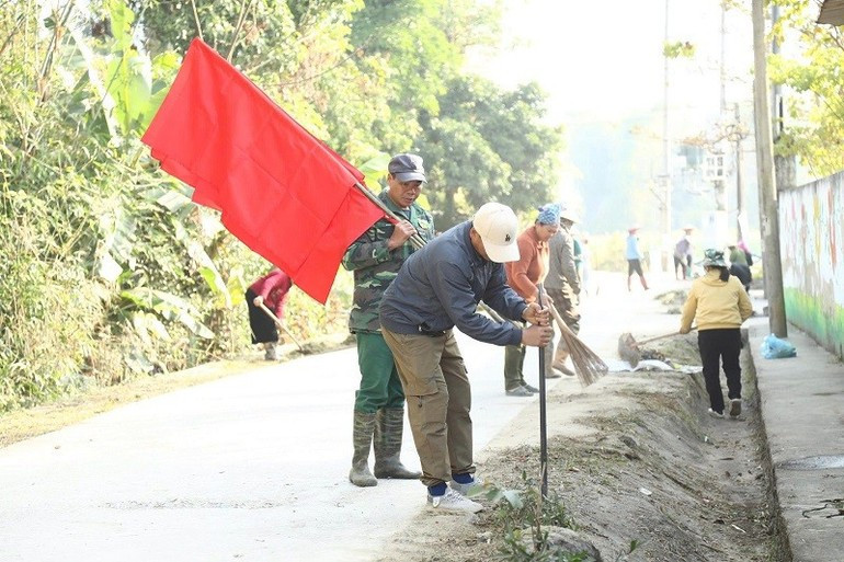 Después de limpiar y ordenar los caminos, los pobladores encajan improvisados mástiles donde ondearán las banderas.