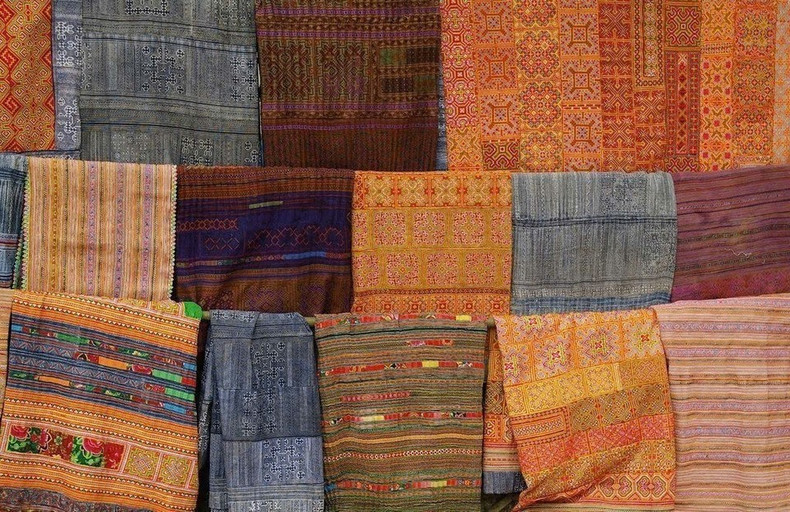 Productos de lino y tejidos tradicionales de Lung Tam con colores y patrones característicos del pueblo Hmong.