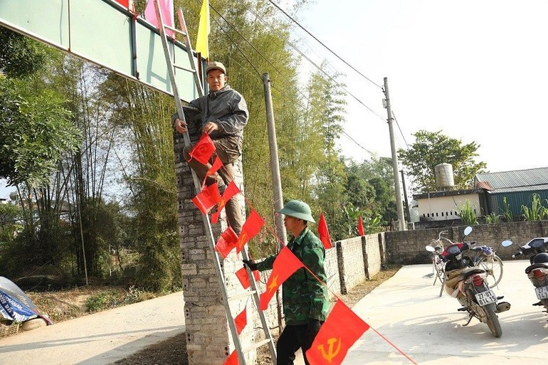 Soldados y pobladores de la comuna de Thanh Nua ornamentan los caminos y las casas en la zona.