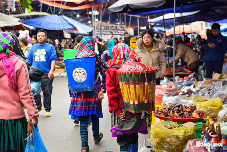 Las mujeres llevan sobre sus espaldas productos agrícolas.