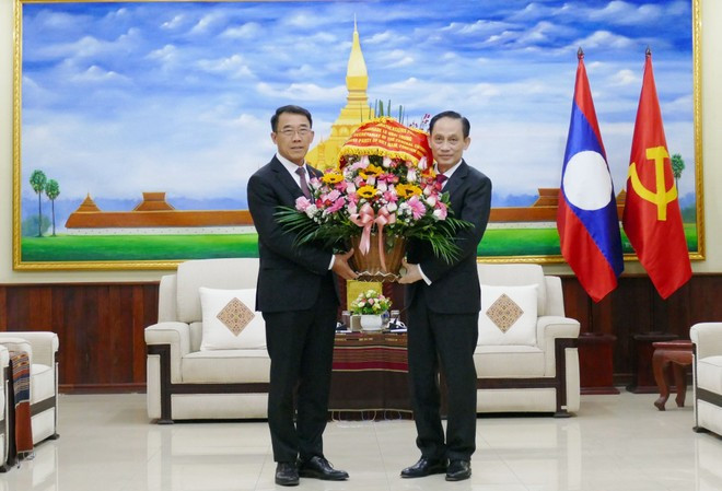 El ministro de Relaciones Exteriores de Vietnam, Le Hoai Trung, felicita a Bounleua Phandanouvong, jefe de la Comisión de Asuntos Exteriores del Comité Central del PPRL. (Foto: VNA)