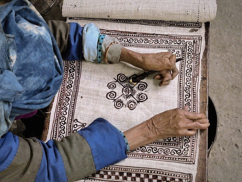 Dibujo de motivos con cera de abejas sobre tela de lino cruda.