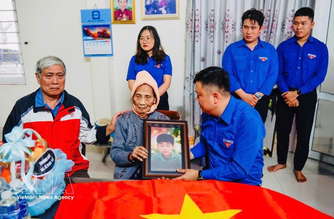 Jóvenes de la ciudad de Da Nang entregan a familiares imágenes restauradas de mártires caídos. (Foto: VNA)
