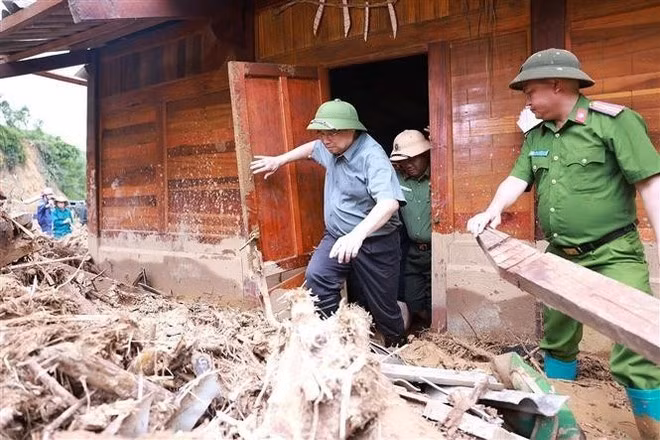 El primer ministro Pham Minh Chinh inspecciona y dirige las labores de recuperación tras las inundaciones, riadas y deslizamientos de tierra en la comuna de Xa Dung. (Foto: VNA)