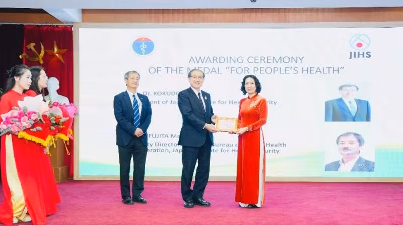La profesora asociada y doctora Nguyen Thi Lien Huong, viceministra de Salud, entrega la Medalla Conmemorativa “Por la Salud del Pueblo” a expertos del JIHS.