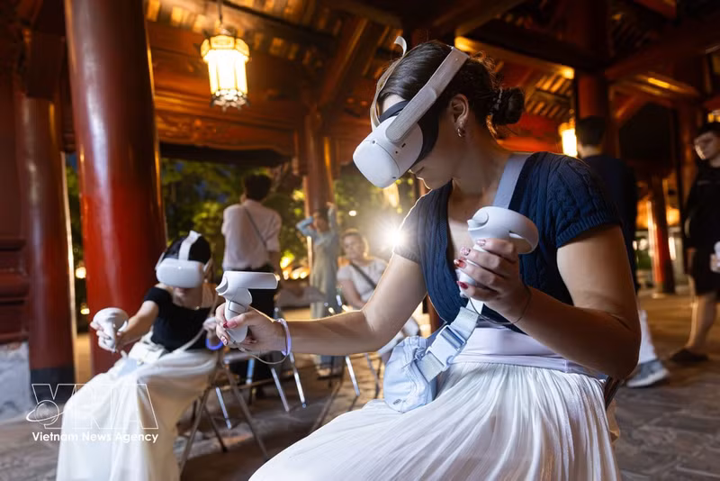 Los turistas extranjeros utilizan dispositivos de realidad virtual para explorar espacios de patrimonio cultural durante las visitas nocturnas. (Fuente: VNA)