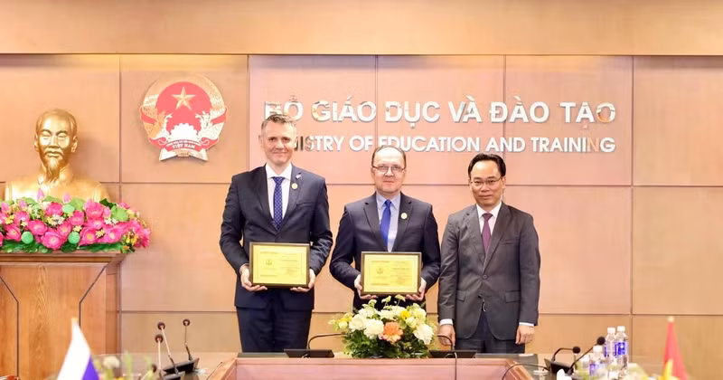 El ministro interino de Educación y Formación de Vietnam, Hoang Minh Son, entrega la placa “Por la causa de la educación” al embajador ruso en Hanói, Gennady Stepanovich Bezdetko, y al consejero de la legación diplomática, Fokin Stanislav.