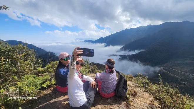 Los turistas participan en el tour turístico de la Roca Sagrada, en la comuna de Pung Luong, provincia de Lao Cai. (Fuente: VNA)
