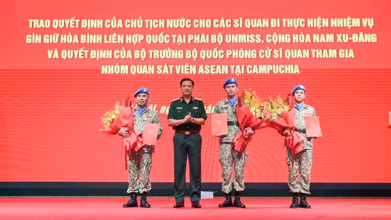El coronel general Nguyen Truong Thang entrega las decisiones a los tres oficiales que partirán hacia la Misión de las Naciones Unidas en Sudán del Sur (UNMISS).